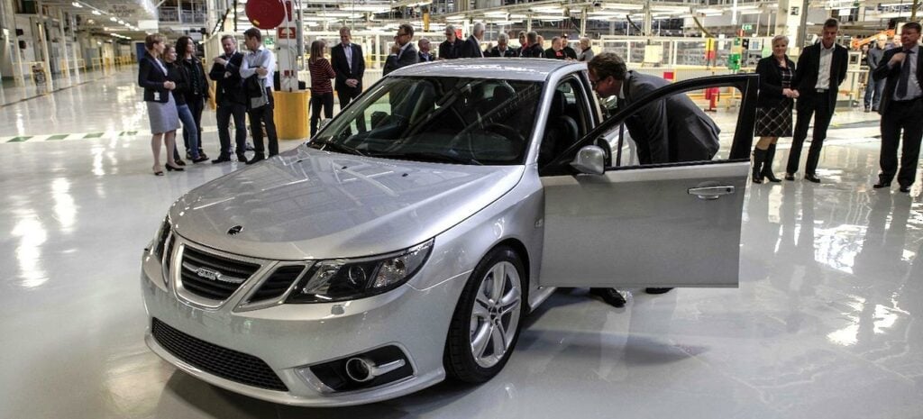 En grupp personer står i en fabrik. (AI text)