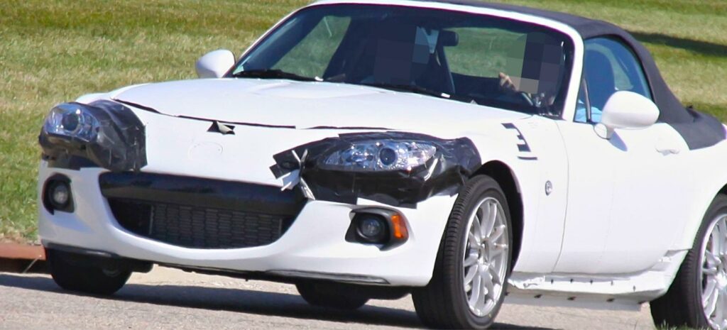 En vit sportbil kör nerför en väg. (AI text)