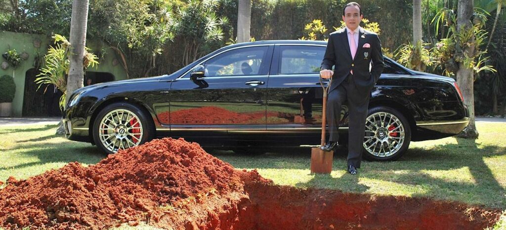 En man i kostym står bredvid en bil. (AI text)