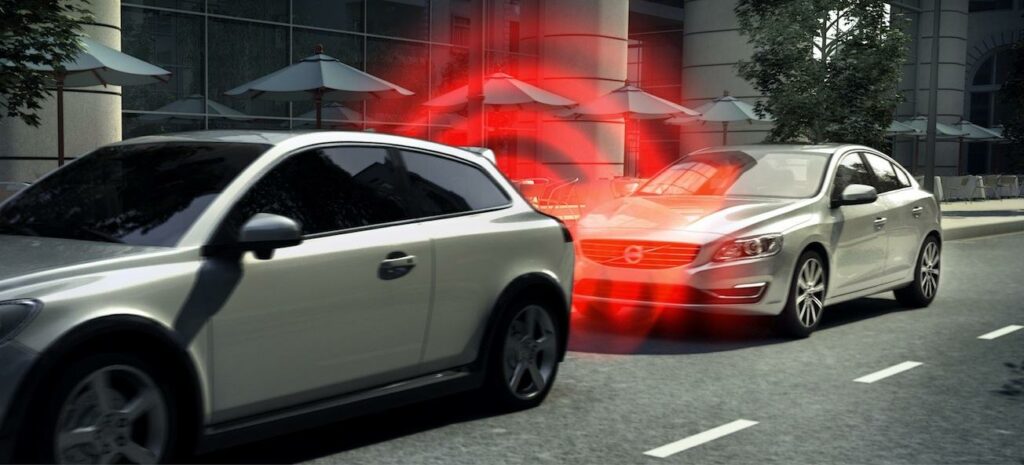 En bil kör nerför gatan med en röd lykta tänd. (AI text)