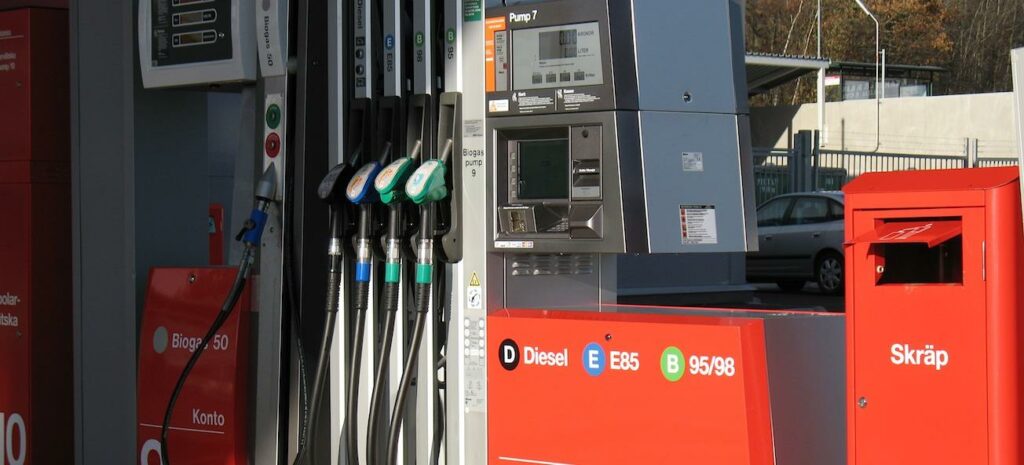 En bensinstation med en röd och vit bil. (AI text)