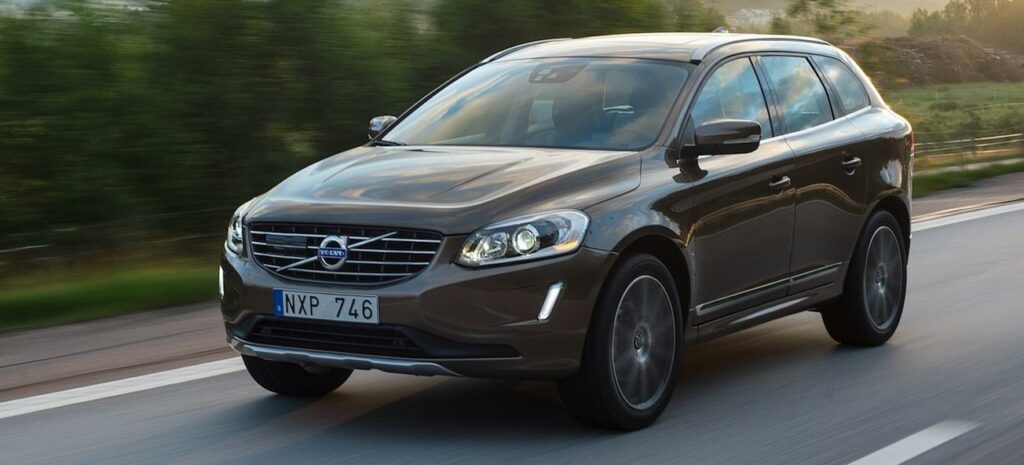 En Volvo XC90 SUV kör längs en landsväg. (AI text)