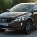 En Volvo XC90 SUV kör längs en landsväg. (AI text)