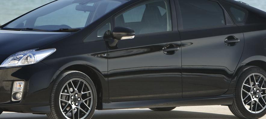 En svart Toyota Prius parkerad på en strand. (AI text)