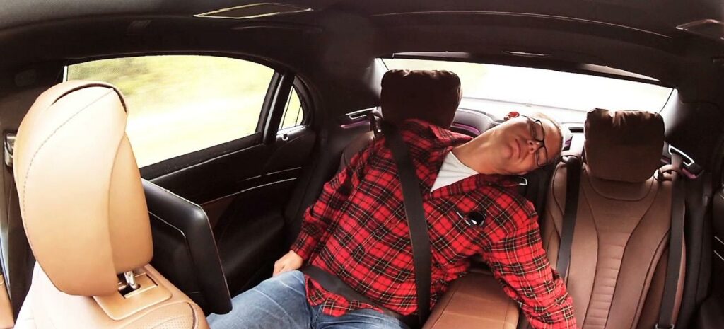 En man sover i baksätet av en bil. (AI text)