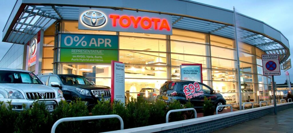En Toyota-återförsäljare med bilar parkerade utomhus. (AI text)