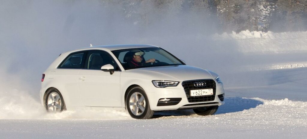 En Audi A3 kör genom snön. (AI text)