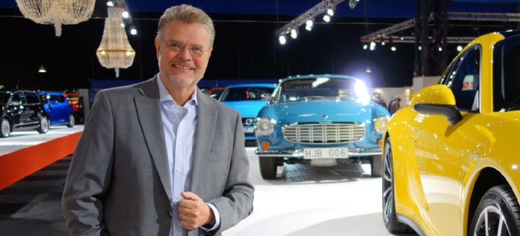 En man står bredvid en gul sportbil. (AI text)