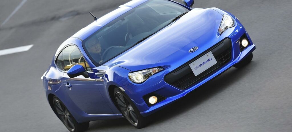 En blå sportbil kör längs en racebana. (AI text)