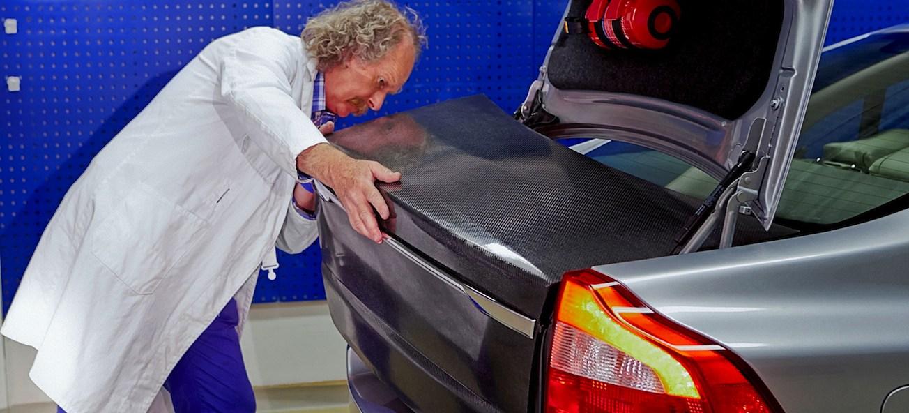 En man i labbrock klämmer på bagageluckan på en bil. (AI text)