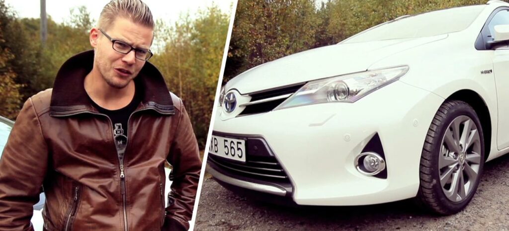 En man i läderskjorta och en man i vit skjorta står bredvid en vit bil. (AI text)