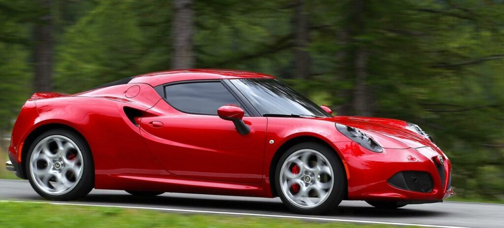 En röd sportbil kör nerför en väg. (AI text)