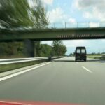 En bil kör nedför en highway. (AI text)