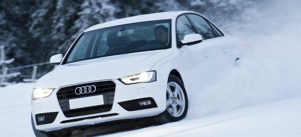 En Audi A3 kör på en snöig väg. (AI text)