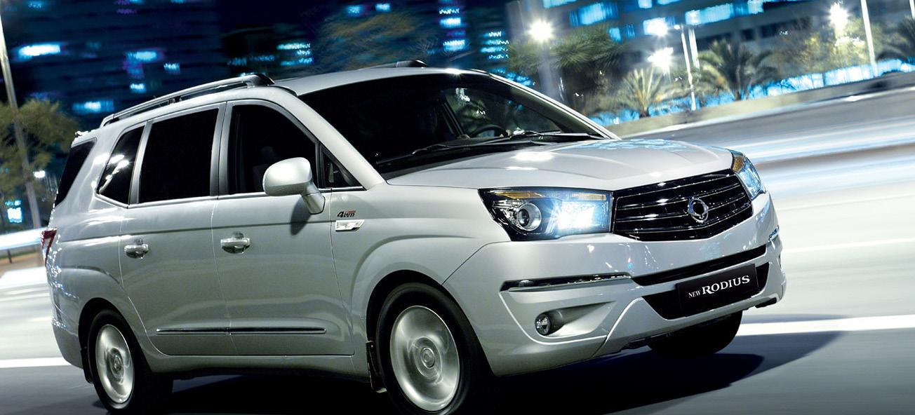 En silverbil kör nedför en stadsgata på natten. (AI text)