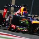 Rött Bull-racingbil kör på en bana. (AI text)