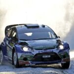En rallybil kör genom en skog. (AI text)