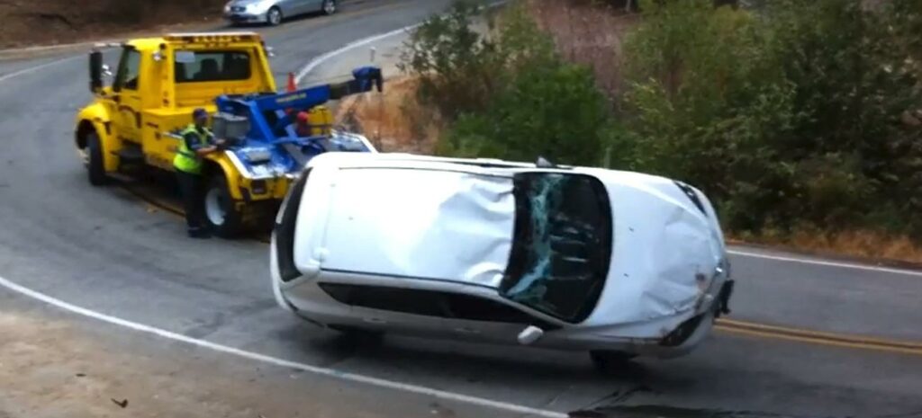 En bil dras bort längs en bergsväg. (AI text)