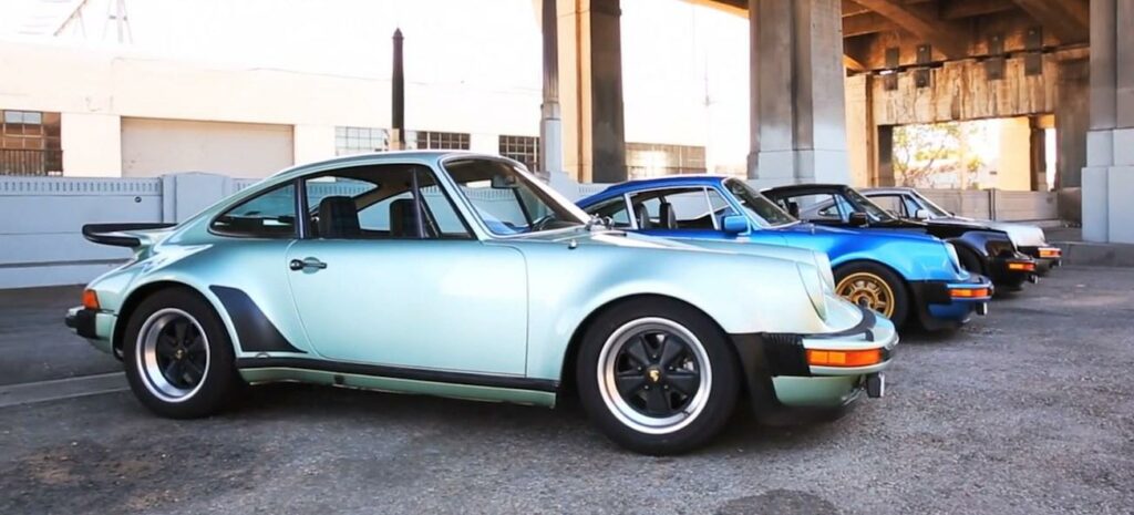 En grupp vintage Porsche bilar parkerade framför ett byggnad. (AI text)