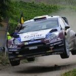 En rallybil hoppas över en grusväg. (AI text)