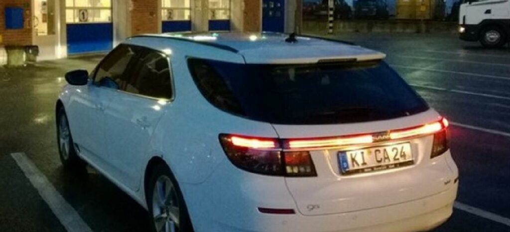 En vit bil parkerad i en parkeringsplats (AI text)