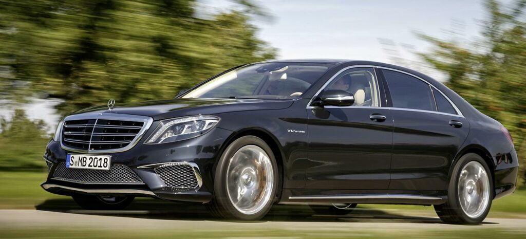 Mercedes-Benz S-klass-sedan kör nedför en landsväg. (AI text)