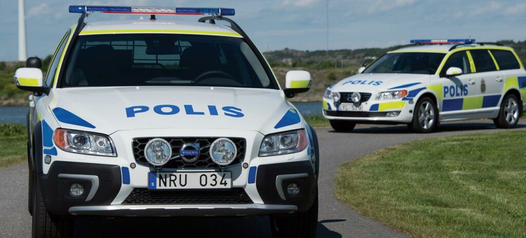 Bilar från polisen parkerade på en landsväg. (AI text)