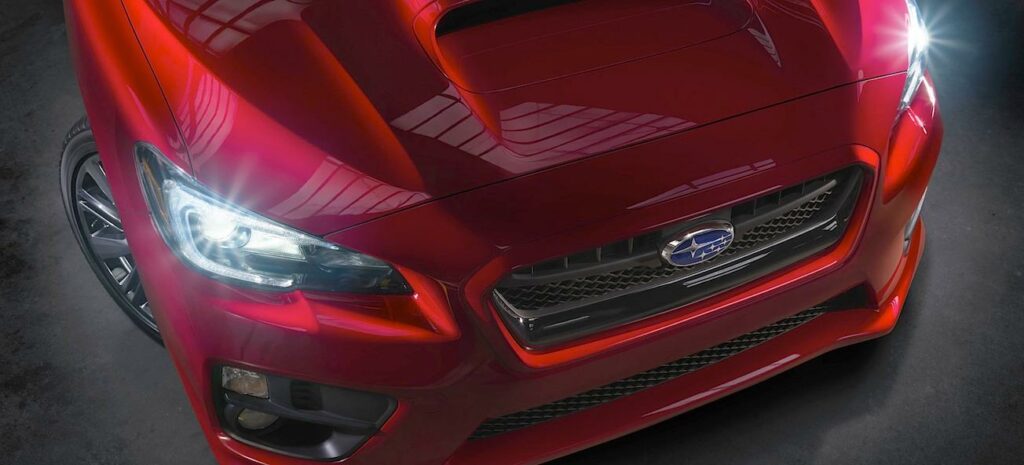 Den nya Subaru WRX STI är en röd bil med en svart grille. (AI text)