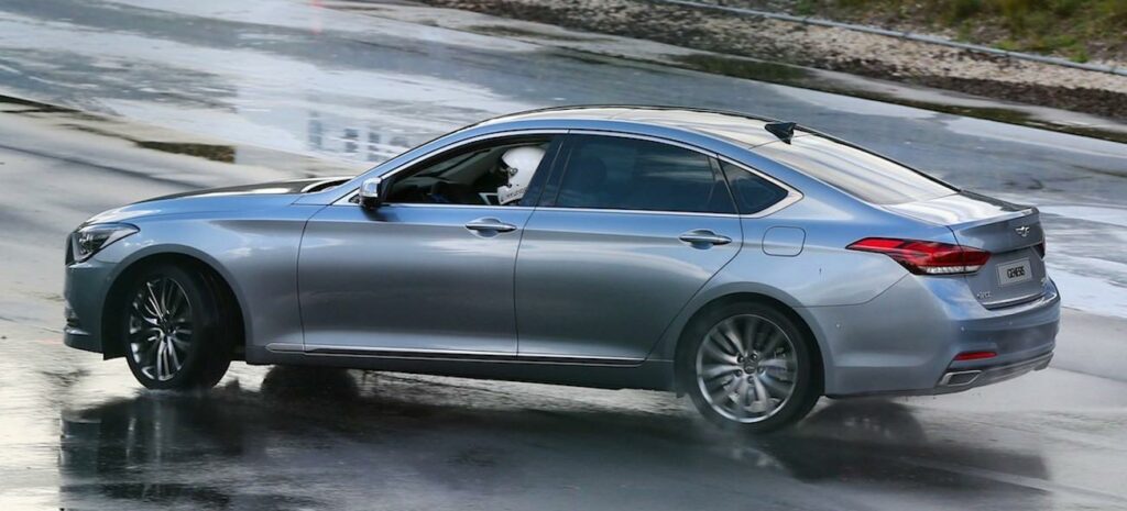 En silverbil kör nedför en blöt väg. (AI text)