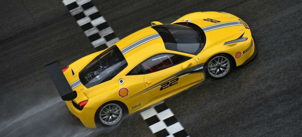 En gul Ferrari-sportbil kör på en bana. (AI text)