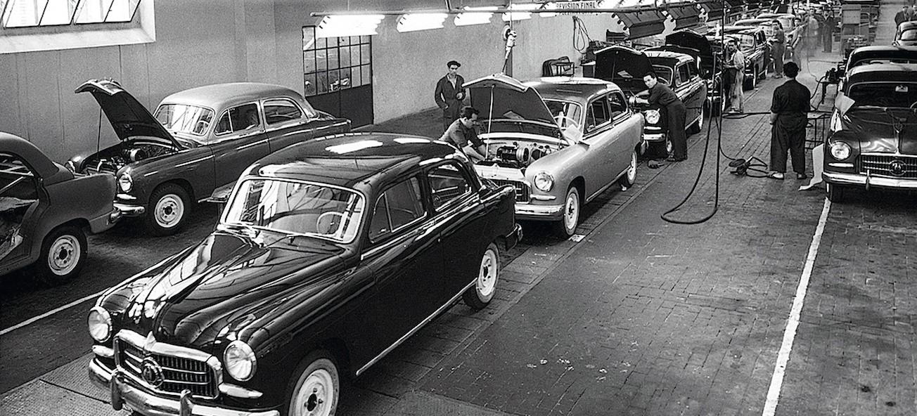 En fabrik med bilar i bakgrunden. (AI text)