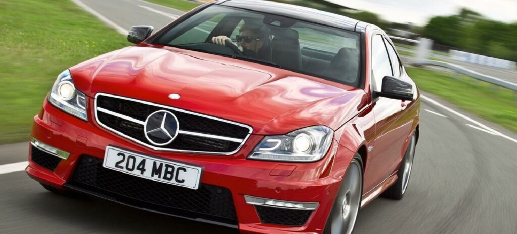 Mercedes-Benz C-klass kör på en väg. (AI text)