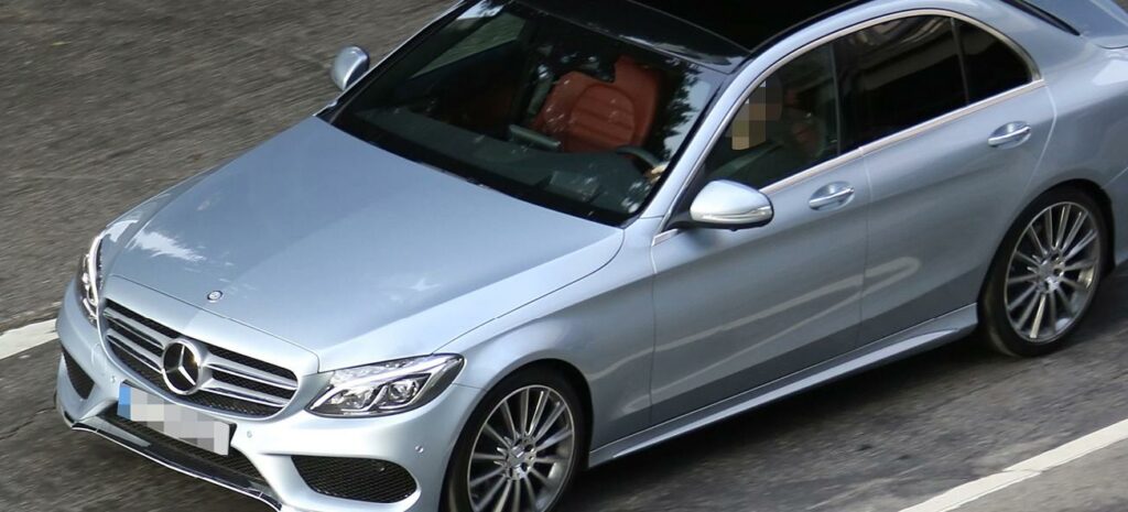 En Mercedes C-klass sedan parkerad på gatan. (AI text)