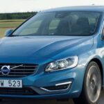 Volvo S60 kör längs vägen. (AI text)