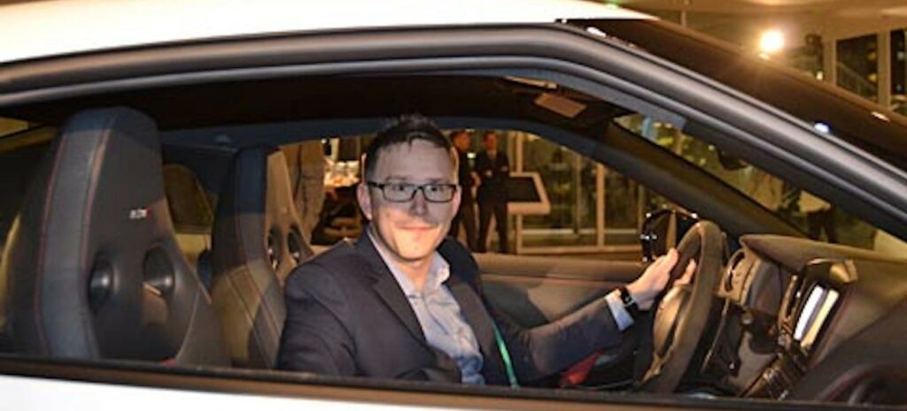 En man i en vit sportbil. (AI text)