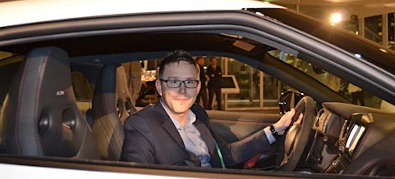 En man i en vit sportbil. (AI text)