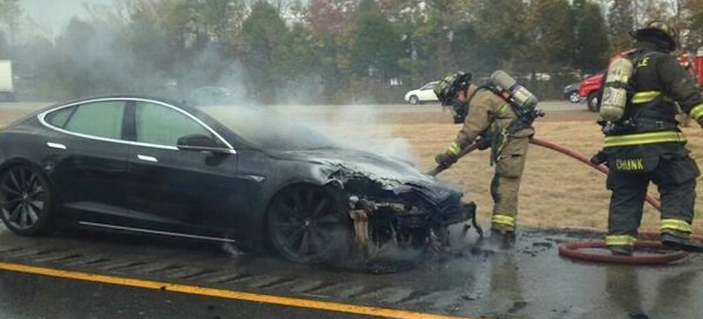 Brandmännen kämpar med en brand på en Tesla Model S. (AI text)