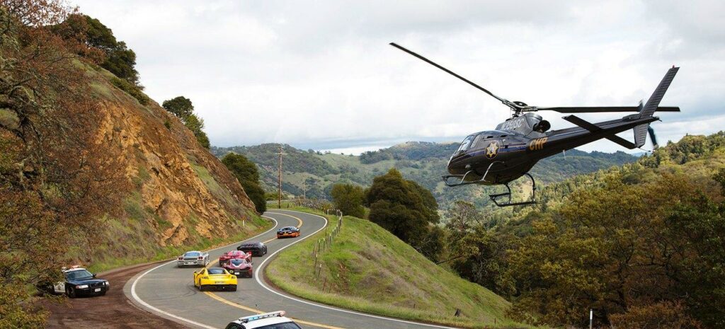 En helikopter flyger över en bergsväg. (AI text)