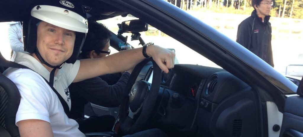 En man i hjälm kör en bil. (AI text)