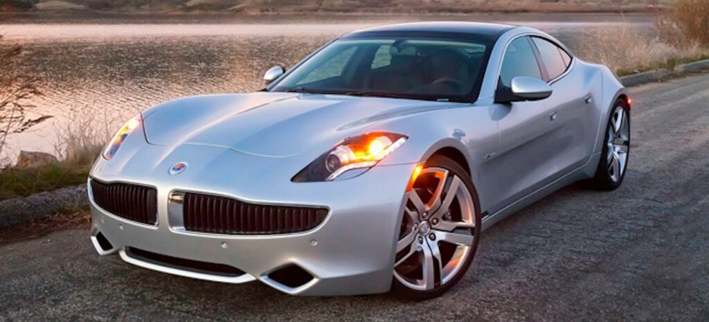 En silverfärgad sportbil parkerad vid en väg vid en sjö. (AI text)