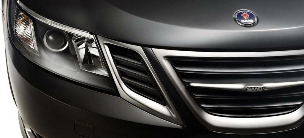 En svart bil med en grill och framlyktor. (AI text)