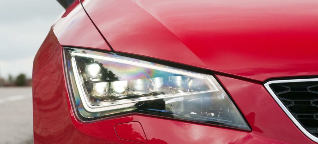 framsidan av en röd bil med en förlysmaskin (AI text)