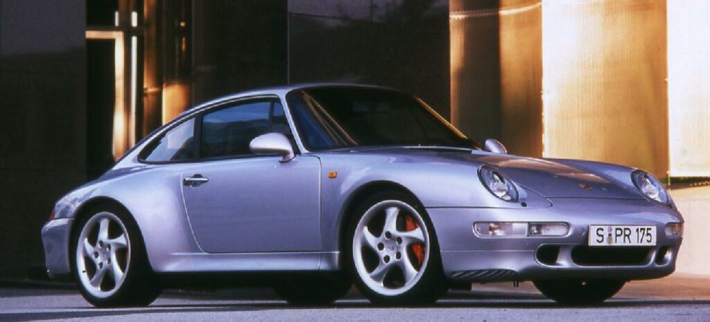 En Porsche 911 GTS parkerad framför ett byggnad. (AI text)