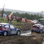 En rallybil körer nedför en smutsig väg. (AI text)