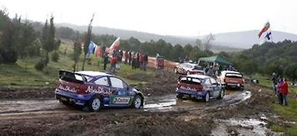 En rallybil körer nedför en smutsig väg. (AI text)