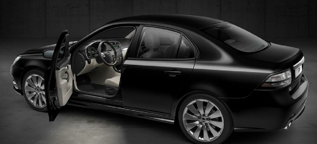 En svart bil med öpprat dörr i en mörk rum. (AI text)