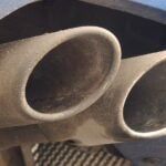 En blå bil med en utluftningsrör. (AI text)