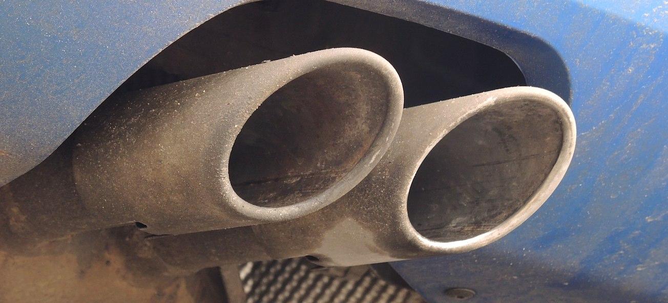 En blå bil med en utluftningsrör. (AI text)