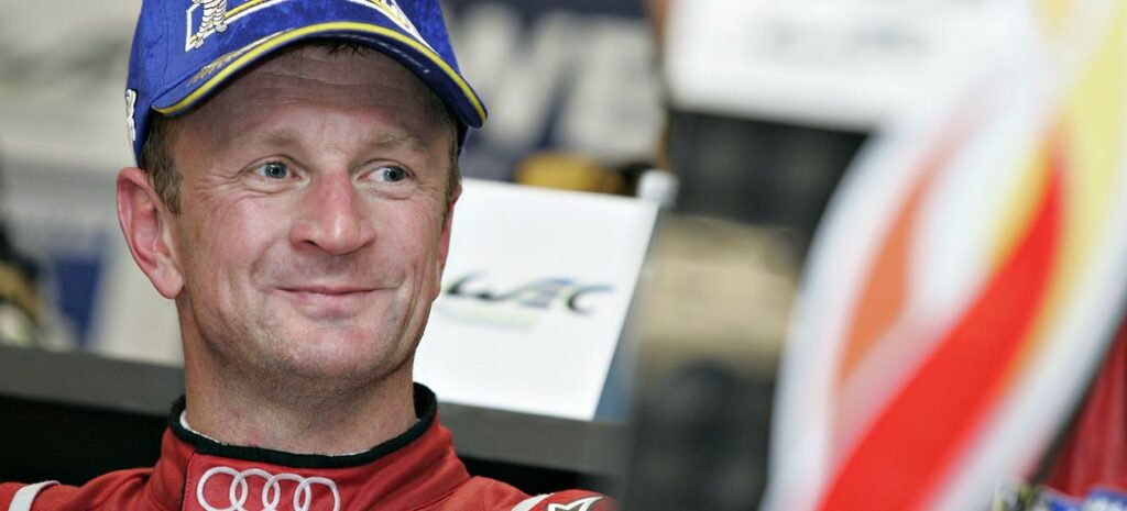 En racerförare i en röd Audi R8 LMS. (AI text)