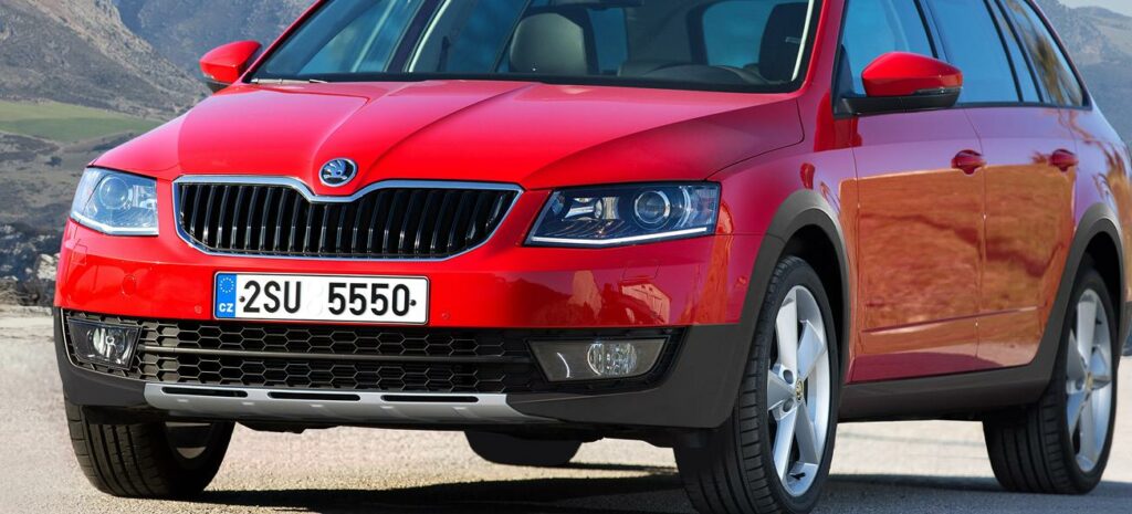 En röd Skoda SUV kör nerför en bergsväg. (AI text)